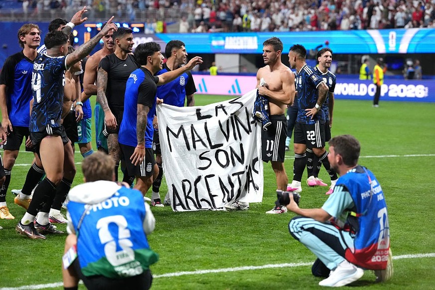 Argentina players hold up a banner with the words 'Las Malvinas son Argentinas' which translates to 'The Malvinas are Argentine' following victory in the FIFA World Cup 2026 semi-f ...