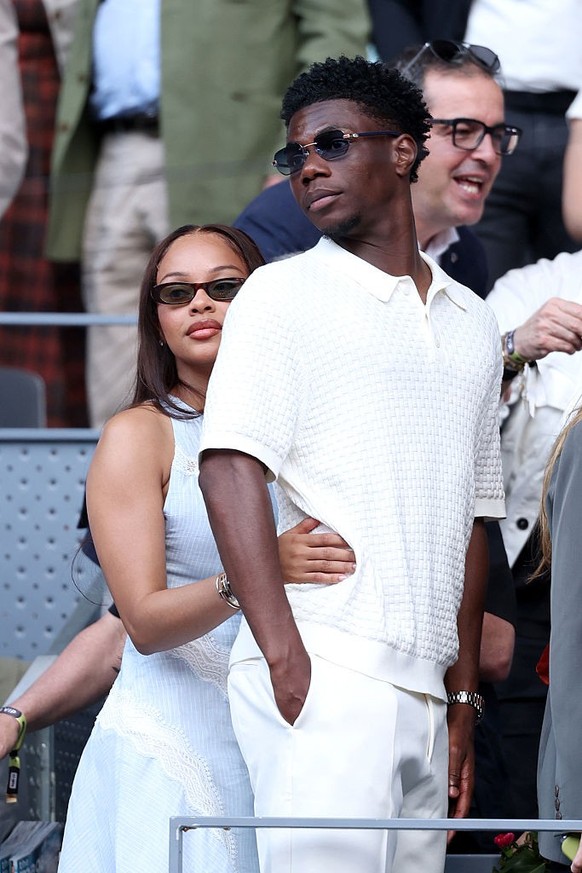 MADRID, SPAIN - MAY 01: Footballer Aurelien Tchouameni of Real Madrid and his partner Suzette Carter leave court after watching Jannik Sinner of Italy against Arthur Fils of France during the Men' ...