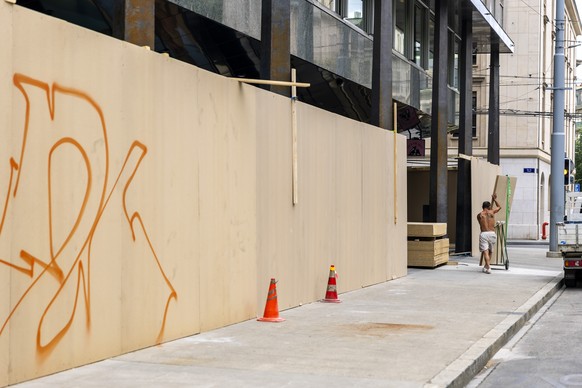 Un ouvrier apporte des planches de bois pour les mettre devant les vitrines d'un etablissement pour le proteger d'eventuelles degradations de la part de manifestants durant la manifestation  ...