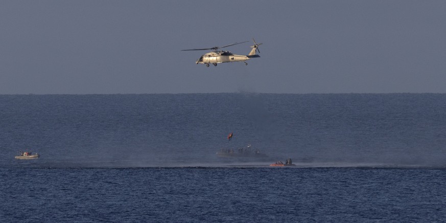 epa12882026 A handout photo made available by the National Aeronautics and Space Administration (NASA) shows a Navy MH-60 Seahawk as it lifts NASA astronaut Artemis II mission specialist Christina Koc ...