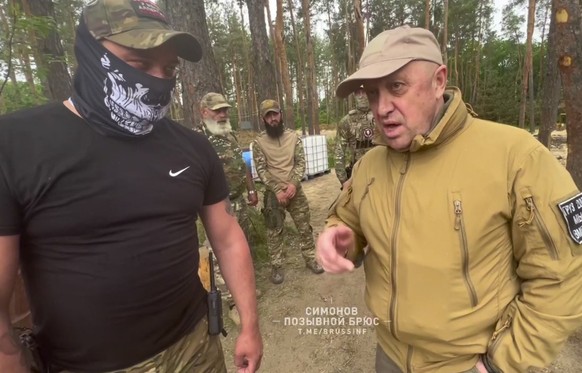 In this handout image taken from a video released by Prigozhin Press Service on Friday, May 26, 2023, head of Wagner Group military company Yevgeny Prigozhin, right, visits a rear camp of a Wagner uni ...