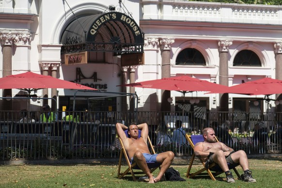 People sit in the sun in Leicester Square, central London, Tuesday July 19, 2022. Britain shattered its record for highest temperature ever registered amid a heat wave that has seized swaths of Europe ...
