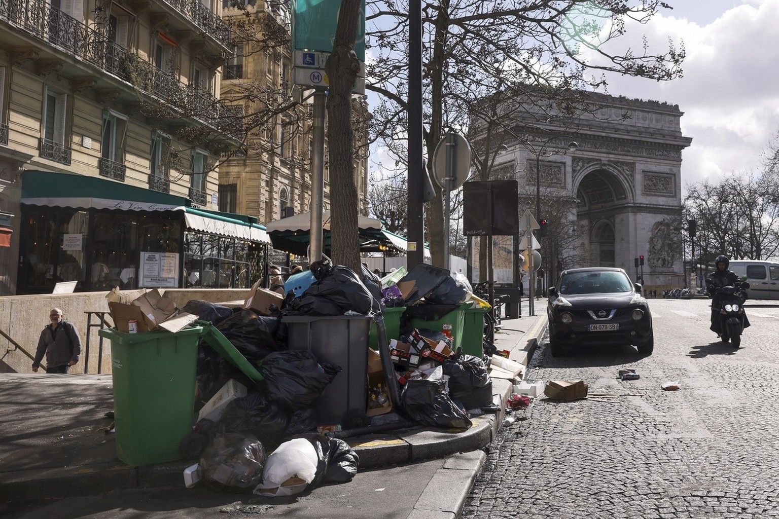 Uncollected garbages are pictured near the Arc de Triomphe in Paris, Tuesday, March 14, 2023. The City of Light is losing its luster with tons of garbage piling up on Paris sidewalks as sanitation wor ...