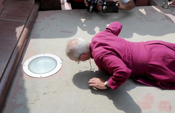 epa07834042 Justin Portal Welby, the Archbishop of Canterbury, prostrates as he pays tribute at the Jallianwala Bagh martyrs&#039; memorial in Amritsar, India, 10 September 2019 (issued 11 September 2 ...