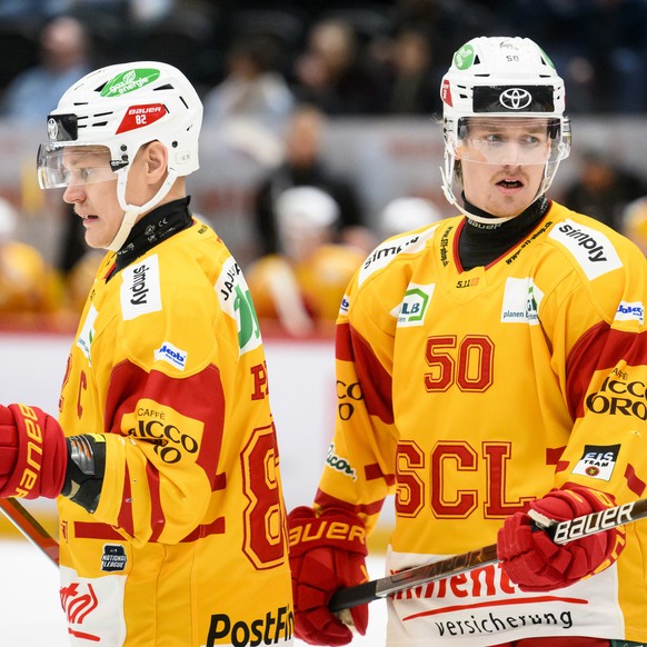 L�attaquant de Langnau Harri Pesonen, gauche, et le defenseur de Langnau Juuso Riikola, droite, portent un protege cou lors du match du championnat suisse de hockey sur glace de National League entre  ...