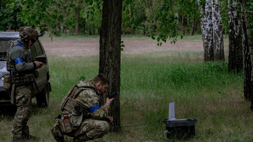 Des soldats ukrainiens utilisent Internet grâce à un terminal Starlink.
