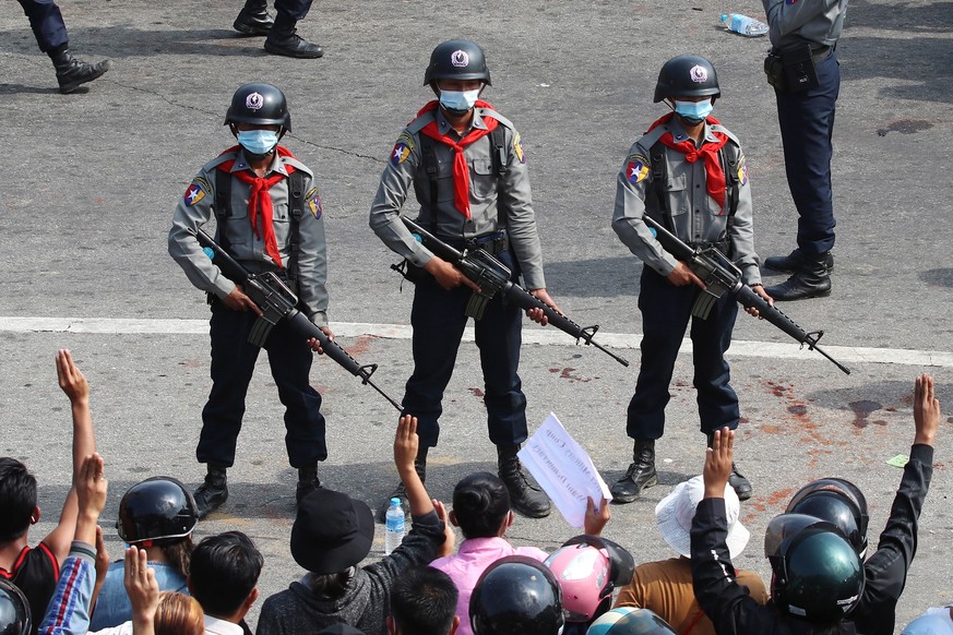 epa09711489 (13/31) (FILE) - Armed anti-riot police stand guard as demonstrators flash the three-finger salute, a symbol of resistance, during a protest against the military, in Naypyitaw, Myanmar, 08 ...