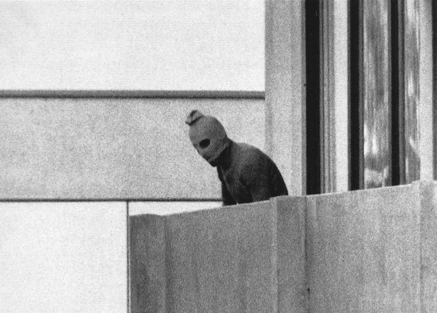 FILE - In this Sept. 5, 1972, file photo, a member of the Arab Commando group which seized members of the Israeli Olympic Team at their quarters at the Munich Olympic Village, appears with a hood over ...
