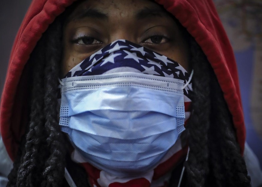 In this April 7, 2020, photo, a subway rider wears a mask and a bandana to protect himself against COVID-19 in New York. As the coronavirus tightened its grip across the country, it is cutting a parti ...