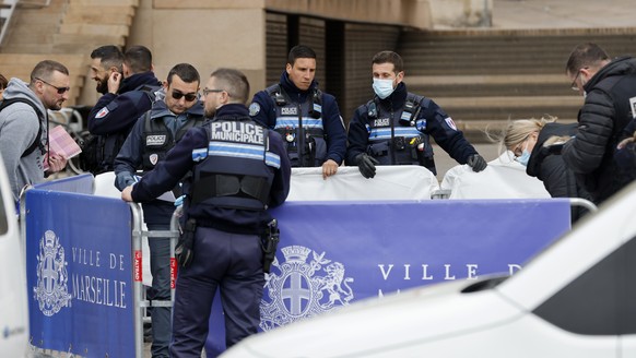 Police officers hide a dead body after a knife attack, outside the Marseille town hall, southern France, Saturday, March 12, 2022. A Frenchman with a knife injured three police officers in the souther ...