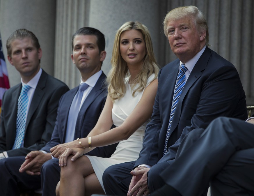 FILE - Donald Trump, right, sits with his children, from left, Eric Trump, Donald Trump Jr., and Ivanka Trump during a groundbreaking ceremony for the Trump International Hotel on July 23, 2014, in Wa ...