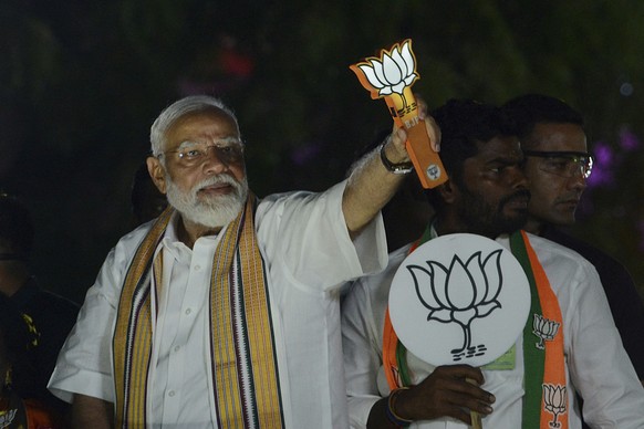 FILE- Indian Prime Minister Narendra Modi displays the Bharatiya Janata Party symbol during an election road show in the southern Indian city of Chennai, India, April 9, 2024. India began counting mor ...