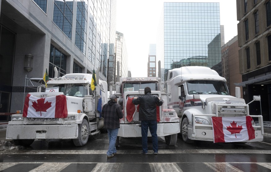 Truck drivers hang a Canadian flag on the front grill of a truck parked in downtown Ottawa, Ontario, near Parliament Hill on Wednesday, Feb. 2, 2022. Thousands of protesters railing against vaccine ma ...