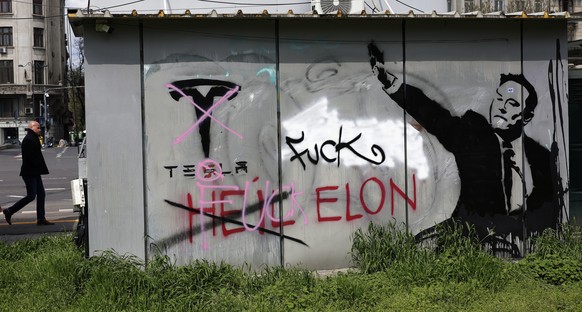 epa12015980 A man passes by a flower shop which back-wall is painted with an ani-Tesla message that also depicts Tesla founder Elon Musk making a gesture resembling with a Nazi like salute, in Buchare ...