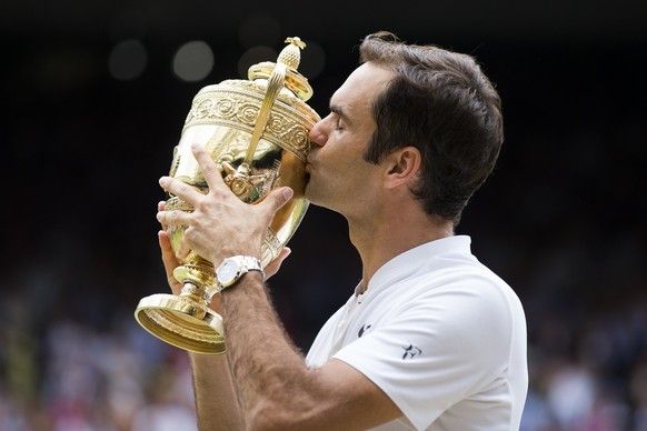 Roger Federer of Switzerland kisses the trophy after winning the men&#039;s final match against Marin Cilic of Croatia during the Wimbledon Championships at the All England Lawn Tennis Club, in London ...