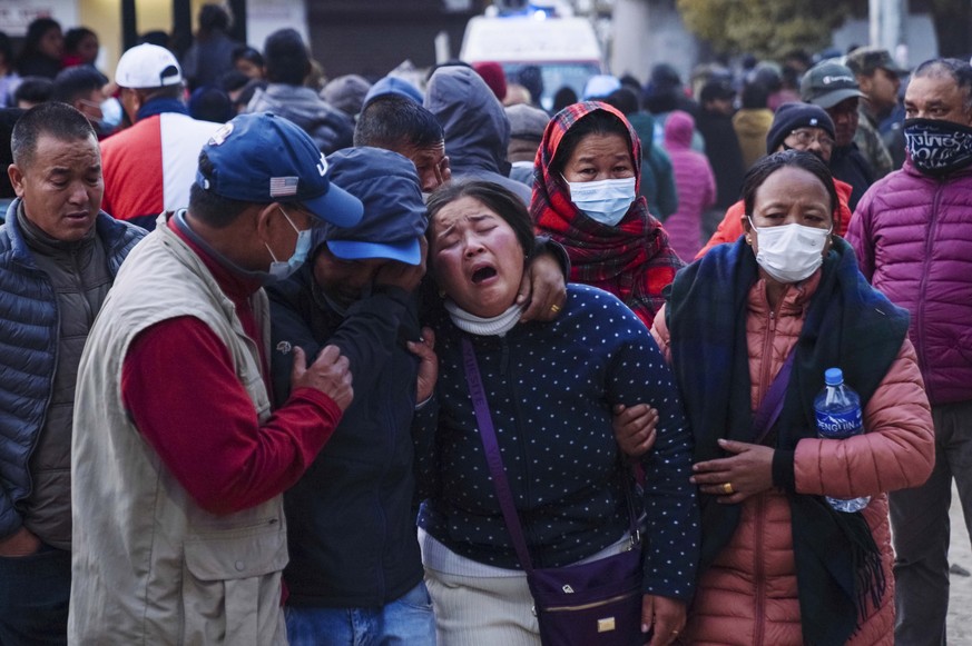 Une femme pleure alors que le corps d'un proche est transporté à l'hôpital de Pokhara, au Népal.