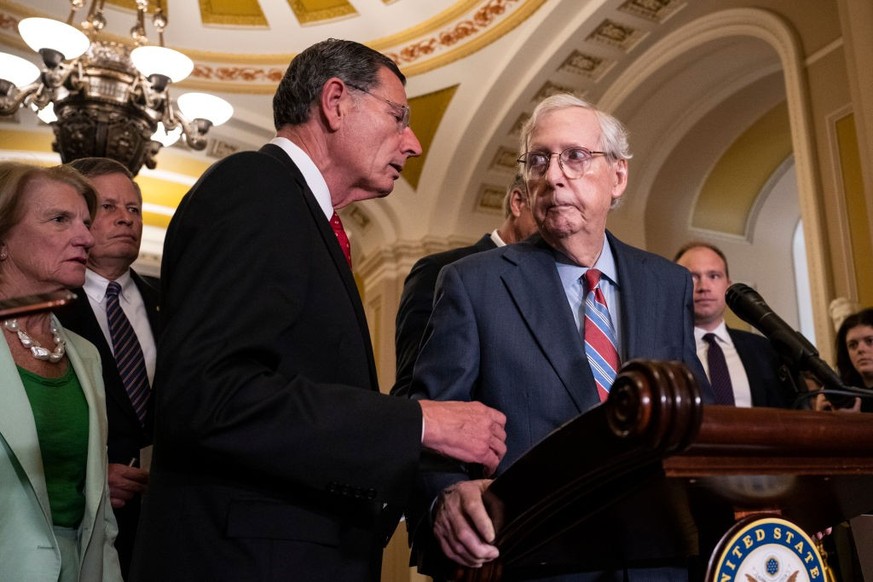 WASHINGTON, DC - JULY 26: (L-R) Sen. John Barrasso (R-WY) reaches out to help Senate Minority Leader Mitch McConnell (R-KY) after McConnell froze and stopped talking at the microphones during a news c ...