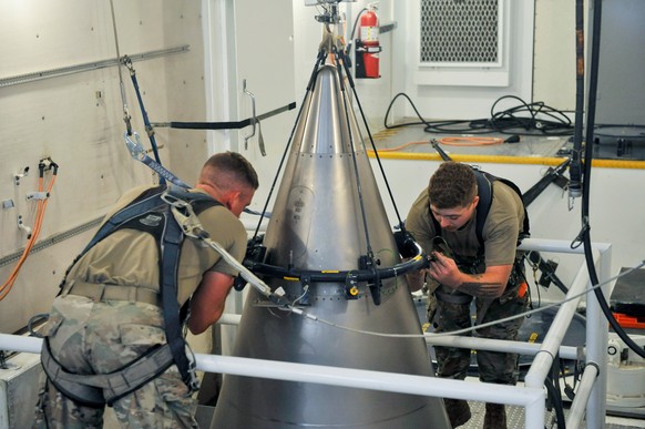 FILE - In this image provided by the U.S. Air Force, Senior Airman Jacob Deas and Airman 1st Class Jonathan Marrs secure a titanium shroud, beneath which is a nuclear warhead, at the top of a Minutema ...