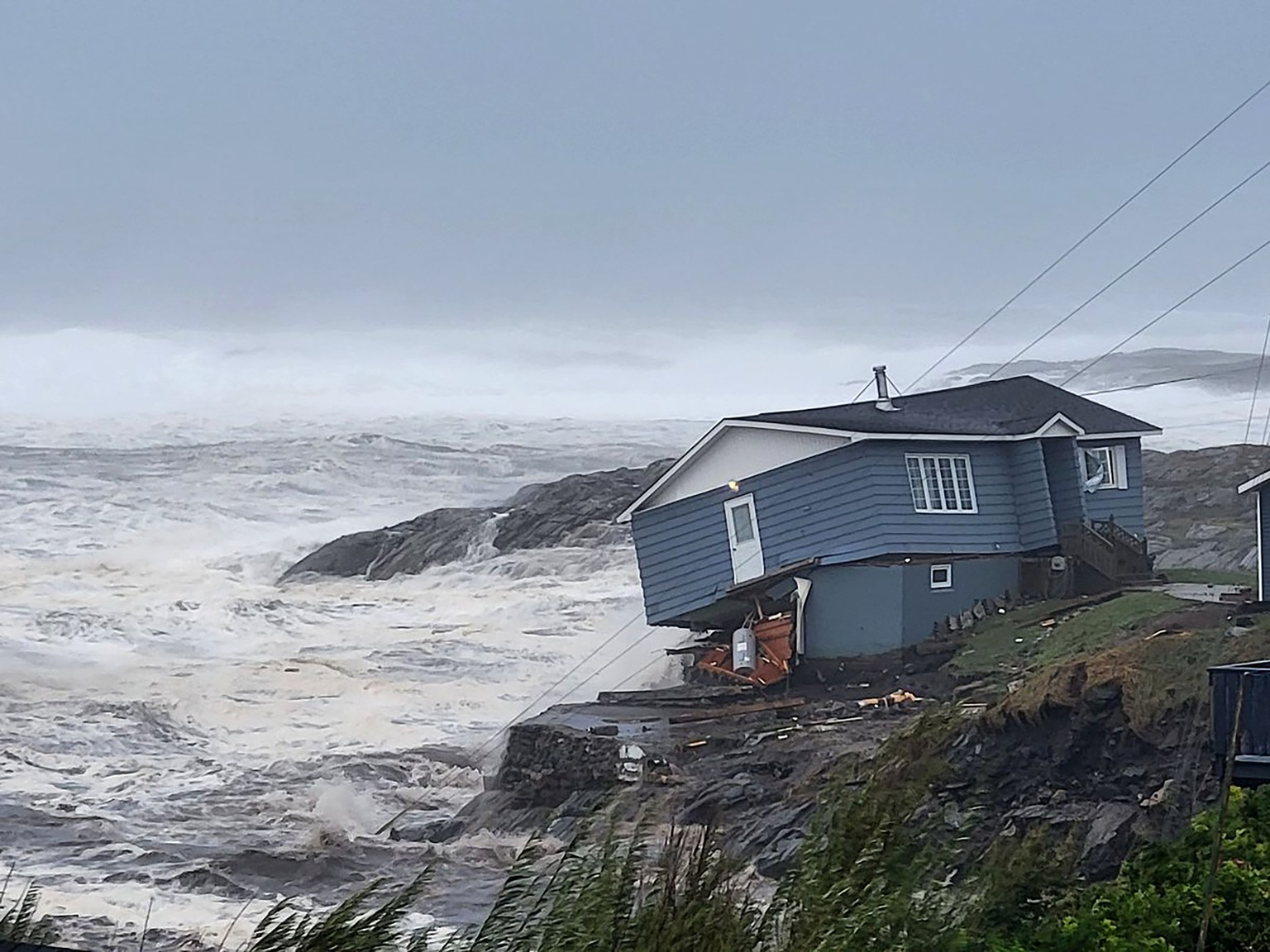 In this photo provided by Wreckhouse Press a home fights against high winds caused by post Tropical Storm Fiona in Port aux Basques, Newfoundland and Labrador, Saturday, Sept. 24, 2022. The home has s ...