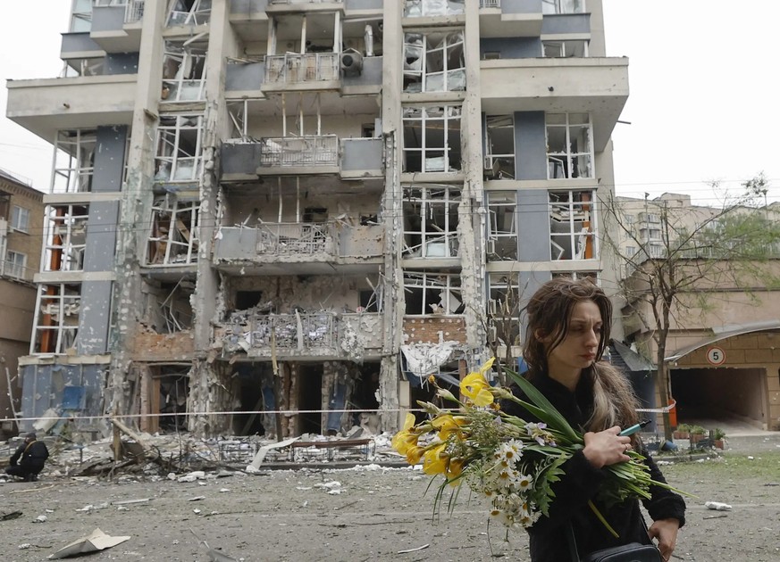 Une habitante de Kiev passe dimanche devant un immeuble d&#039;habitation gravement endommagé la nuit précédente par des missiles russes.