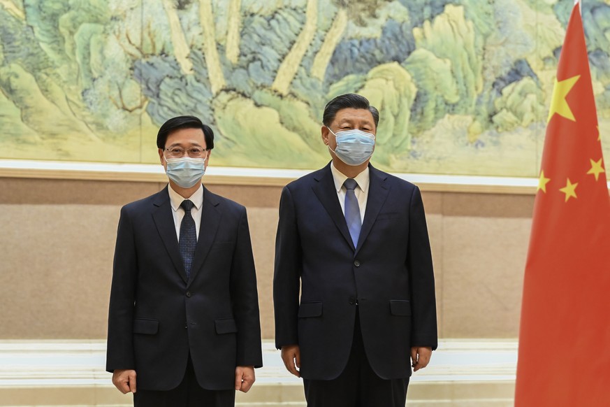 In this photo released by Xinhua News Agency, Chinese President Xi Jinping, right, and Hong Kong Chief Executive-elect John Lee pose for photo before their meeting in Beijing, Monday, May 30, 2022. Ho ...