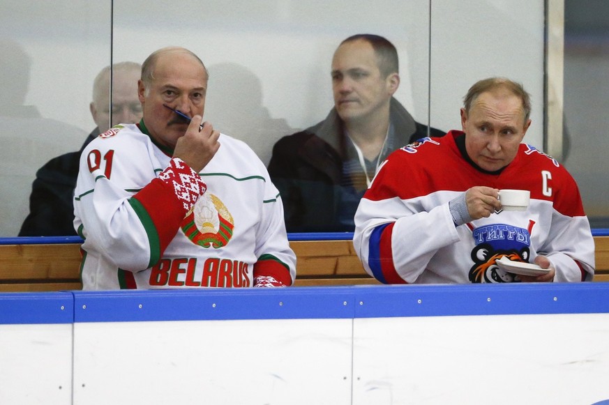 Russian President Vladimir Putin, right, and Belarusian President Alexander Lukashenko take a break during a match of the Night Hockey League teams in Rosa Khutor in the Black Sea resort of in Sochi,  ...