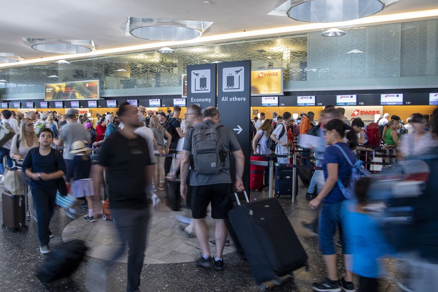 epa10747426 People line up in long queues as they wait in front of the check-in counters to be processed on their way to their holiday destinations, at the airport in Zurich, Switzerland, 15 July 2023 ...