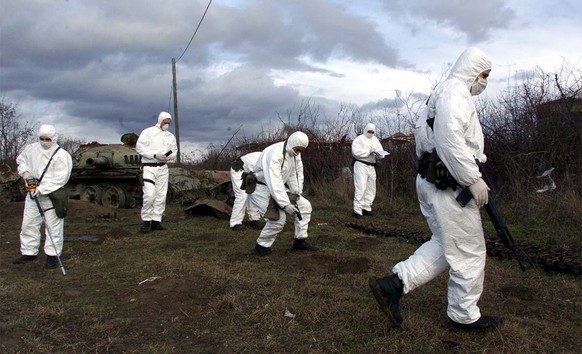 Portuguese and Italian KFOR soldiers measure radiation levels near a Yugoslav Army tank destroyed during NATO bombing campaign, in the western Kosovo town of Klina, Tuesday, January 9, 2001. There are ...