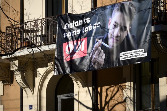 Une banderole representant une affiche &quot;Enfants sans tabac&quot; incitant a voter oui a l&#039;interdiction de la publicite pour le tabac qui pousse les enfants a fumer est photographiee ce mardi ...