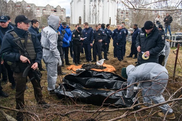 French forensics investigators, who arrived to Ukraine for the investigation of war crimes amid Russia&#039;s invasion, stand next to a mass grave in the Bucha, Kyiv area, Ukraine, April 12, 2022 (Pho ...