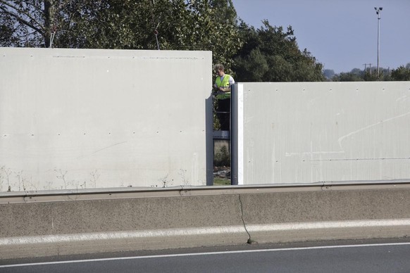 A worker build a 4 meters (13-foot) high wall along the roadway leading to the Calais port, outside Calais, northern France, Saturday, Oct. 15, 2016. The kilometer-long wall being paid for by Britain, ...