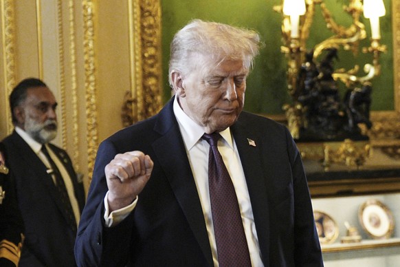 President Donald Trump gestures during a visit to the Royal Collection exhibition with Britain&#039;s King Charles III, and Queen Camilla, in the Green Drawing Room at Windsor Castle, in Windsor, Engl ...