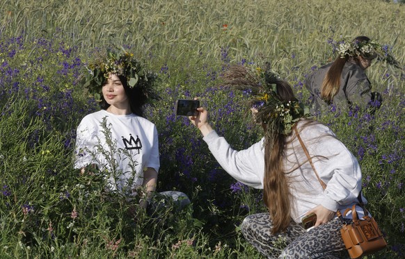 KEYPIX - epa12189943 A woman poses for a photo with a flower chaplet, as Ukrainians participate in the celebrations of the traditional pagan holiday of Ivana Kupala in Kyiv, Ukraine, 21 June 2025, ami ...