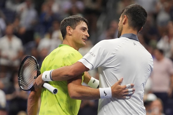 Novak Djokovic, of Serbia, right, embraces Mariano Navone, of Argentina, after Navone won their match during the first round of the U.S. Open tennis championships Sunday, Aug. 30, 2026, in New York. ( ...