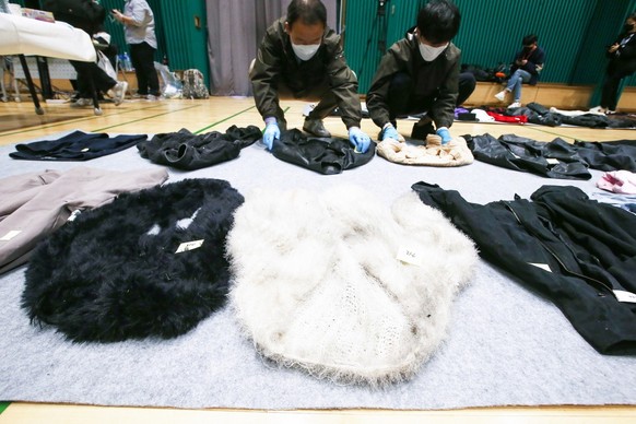 Police officers check clothes collected from the scene of an stampede, at a multi-purpose gym in Seoul, South Korea, 01 November 2022. According to the National Fire Agency, at least 154 people were k ...