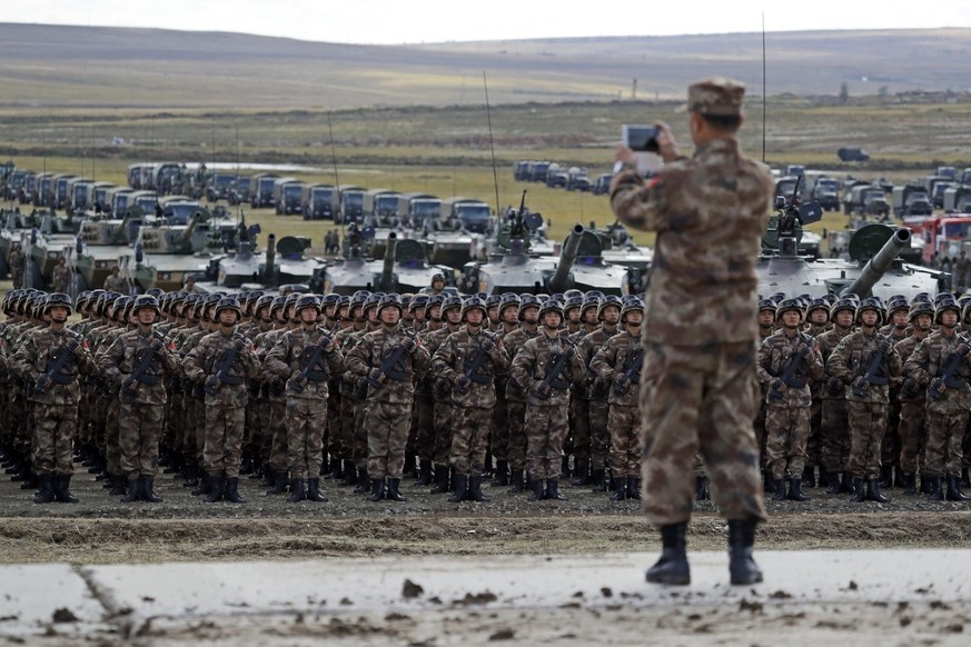 A Chinese officer takes a photo of Chinese troops as they parade during a military exercises on training ground &quot;Tsugol&quot;, about 250 kilometers (156 miles ) south-east of the city of Chita du ...