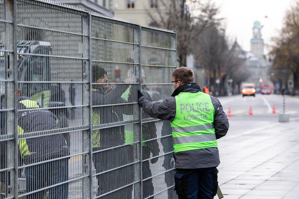 Polizisten und Logistikpersonal stellen einen Schutzzaun auf dem Bundesplatz auf, am Sonntag, 28. November 2021, in Bern. Erstmals wird an einem Abstimmungssonntag der Bundesplatz abgeriegelt. Die Geg ...