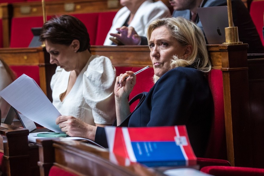 Member of the National Assembly for the far-right Rassemblement National (RN) party Marine Le Pen (R) looks on during the debate on the 2022 rectifying finance bill in the hemicycle of the National As ...