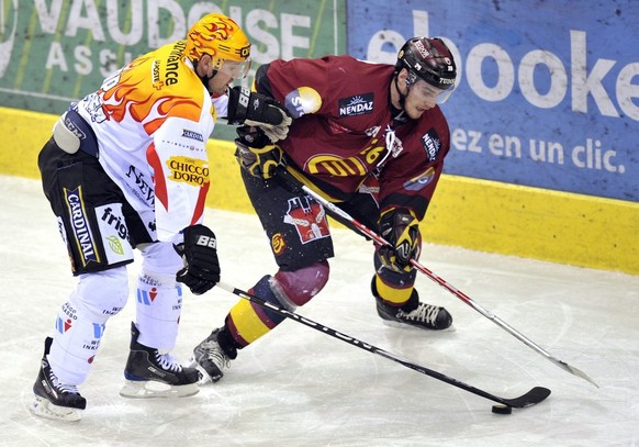 Le Fribourgeois Serge Aubin, gauche, a la lutte pour le puck avec le Genevois Christopher Rivera, droite, lors des quart de finales de play-off du championnat suisse de hockey sur glace de National Le ...