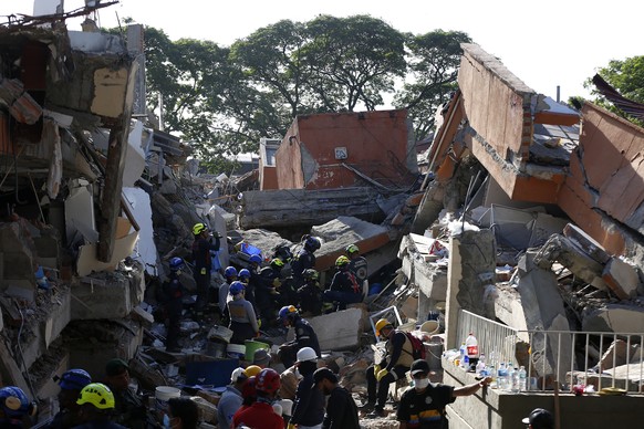 epa13161564 Rescue workers search for missing people in the rubble of the Torres del Limonar residential building following a 7.4-magnitude earthquake, in Cali, Colombia, 11 August 2026. At least 181  ...