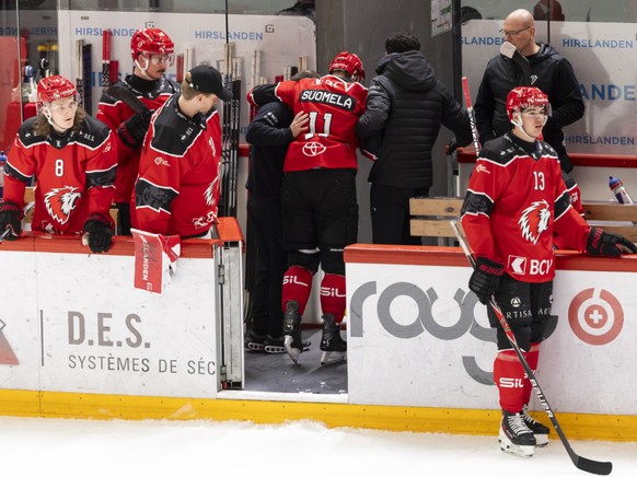 Antti Suomela soutenu par des membres du staff pour sortir de la glace