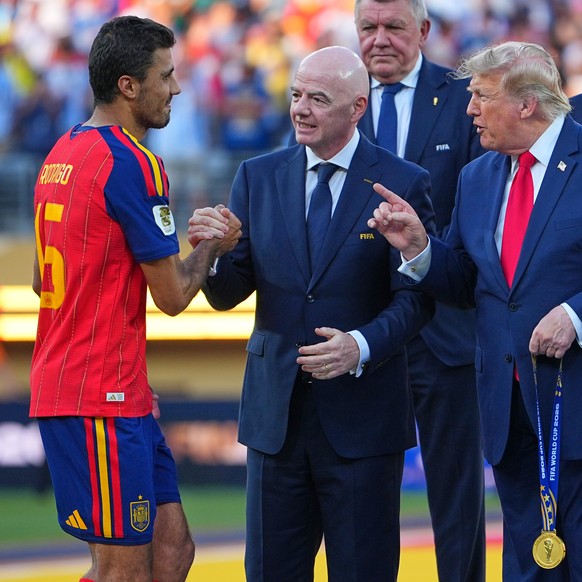 Spain's Rodri (16) is greeted by FIFA President Gianni Infantino and President Donald J. Trump during the presentation ceremony after the World Cup final soccer match between Spain and Argentina  ...