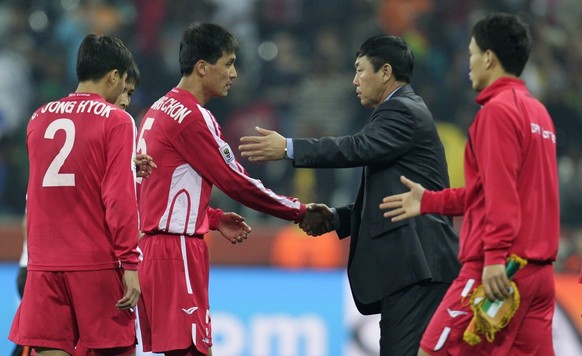epa02222405 North Korea coach Kim Jong Hun (2nd R) greets players after North Korea lost 3-0 to Ivory Coast and failed to advance to the Round of 16 after the FIFA World Cup 2010 group G preliminary r ...