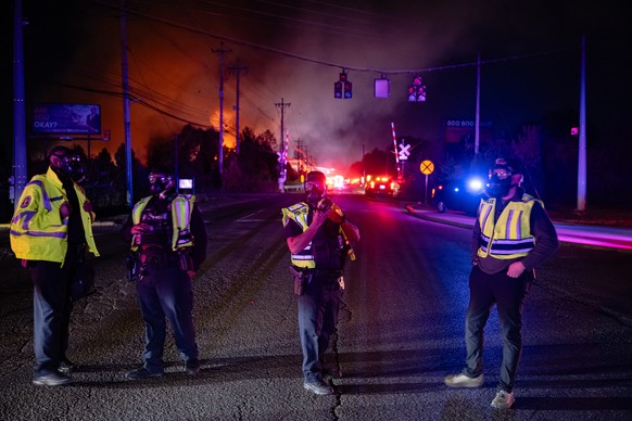 Members of law enforcement wear respirators near the area of the reported plane crash at Louisville Muhammad Ali International Airport on Tuesday, Nov. 4, 2025, in Louisville, Ky. (AP Photo/Jon Cherry ...