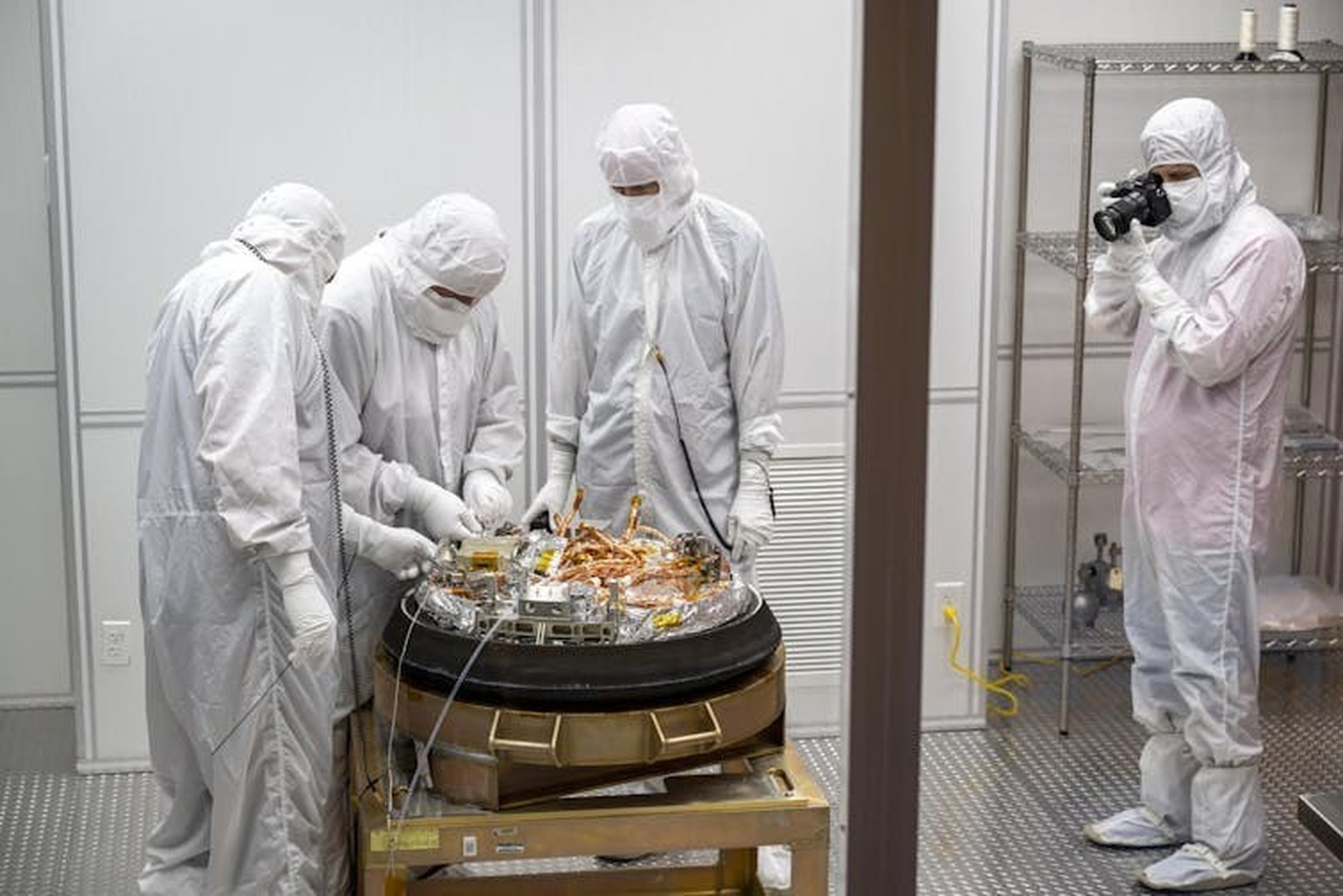 Les équipes de conservation traitent la capsule d’échantillons de retour de la mission OSIRIS-REx (NASA) dans une salle blanche.