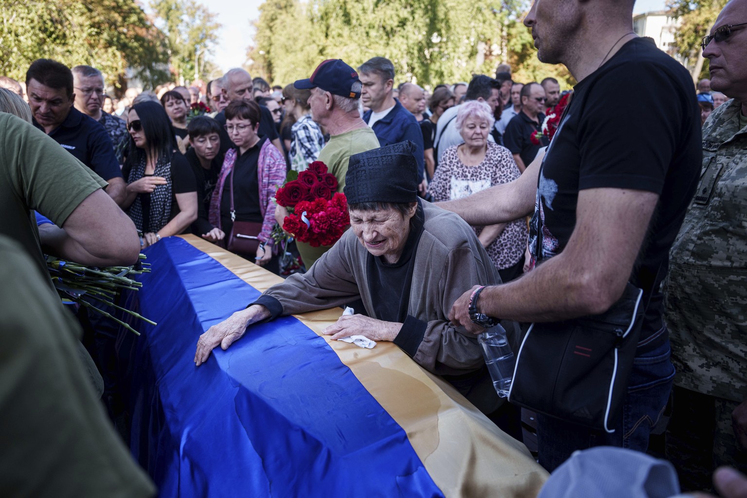 A mother cries near the coffin of her son killed in a Russian rocket attack at a Ukrainian military academy, during his funeral ceremony in Poltava, Ukraine, Saturday Sept. 7, 2024. (AP Photo/Evgeniy  ...