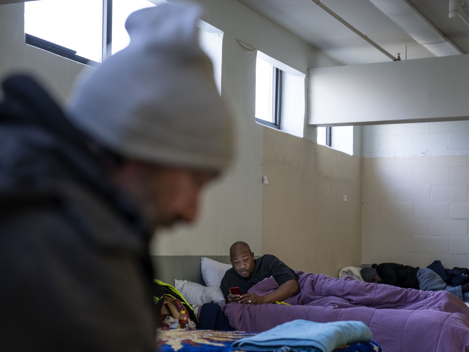 Thomas Moore, right, rests on his bed inside a shelter at Crossroads Rhode Island during a wave of frigid weather in Providence, R.I., Friday, Feb. 3, 2023. The shelter extended their hours to allow r ...