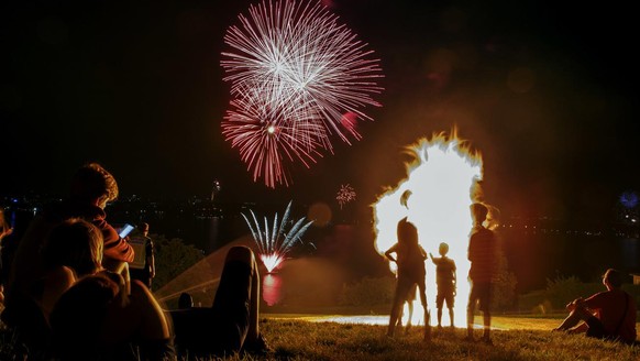 Spectators watch the traditional bonfire with a fireworks, during the Swiss National Day, in Cologny near Geneva, Switzerland, Tuesday, August 1, 2017. (KEYSTONE/Salvatore Di Nolfi)