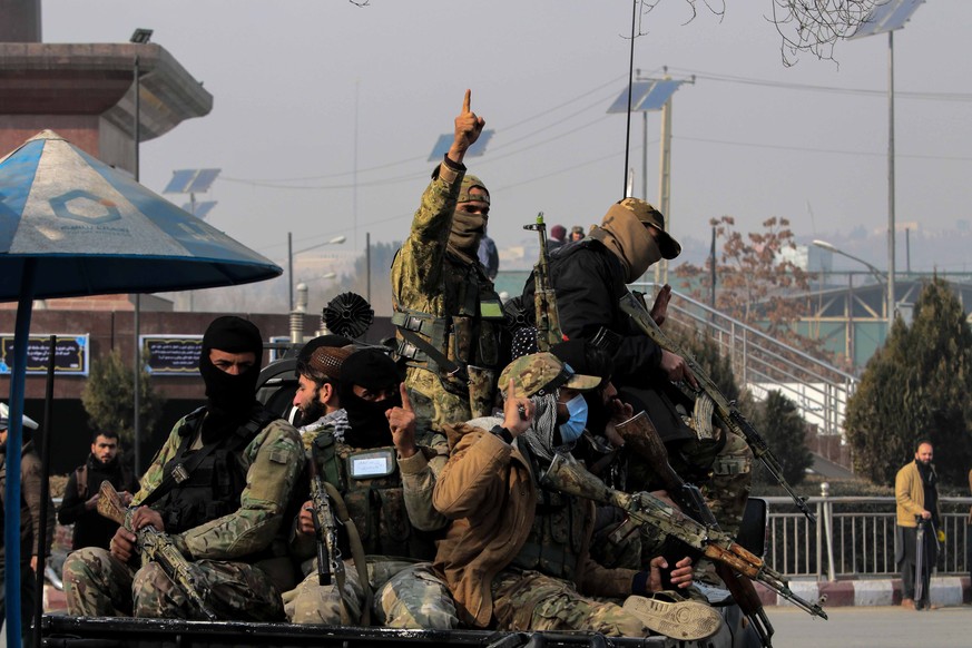 epa09652498 Taliban patrol during a protest by Afghans, outside the building of former US embassy, demanding the US to unfreeze Afghan assets, in Kabul, Afghanistan, 21 December 2021. The Taliban gove ...