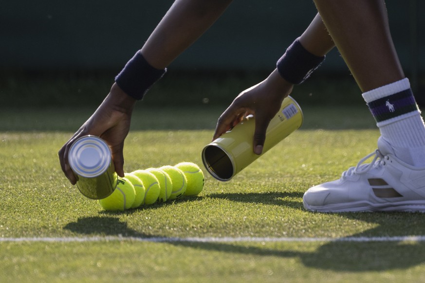 A steward empties two cans with new balls during a second round match of the Qualifying competition for the All England Lawn Tennis Championships in Roehampton, London, Wednesday, June 26, 2024. The W ...